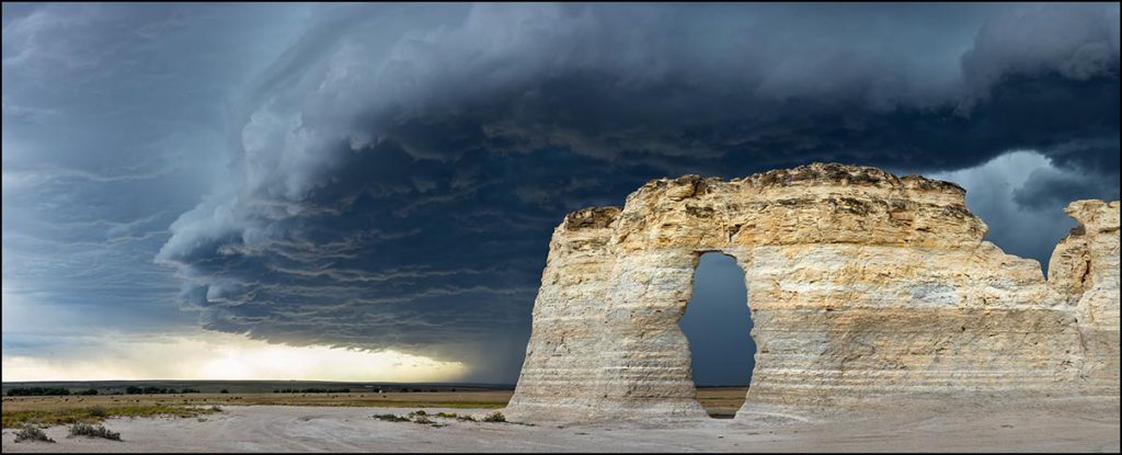large rock formation with stormy clouds overhead