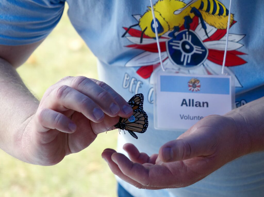 Allan holds a tagged monarch butterfly at ICT Beefest 2023