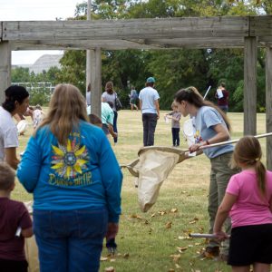 Volunteer Alicia teaches families how to use the canvas insect nets.